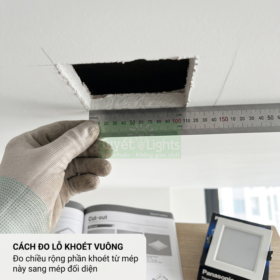 Thợ dùng thước thép đo lỗ khoét vuông trên trần để lắp đèn âm trần Panasonic