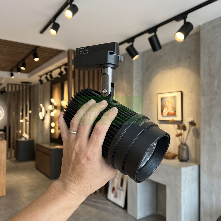 Đèn rọi ray LED màu đen được cầm trên tay trong showroom nội thất hiện đại