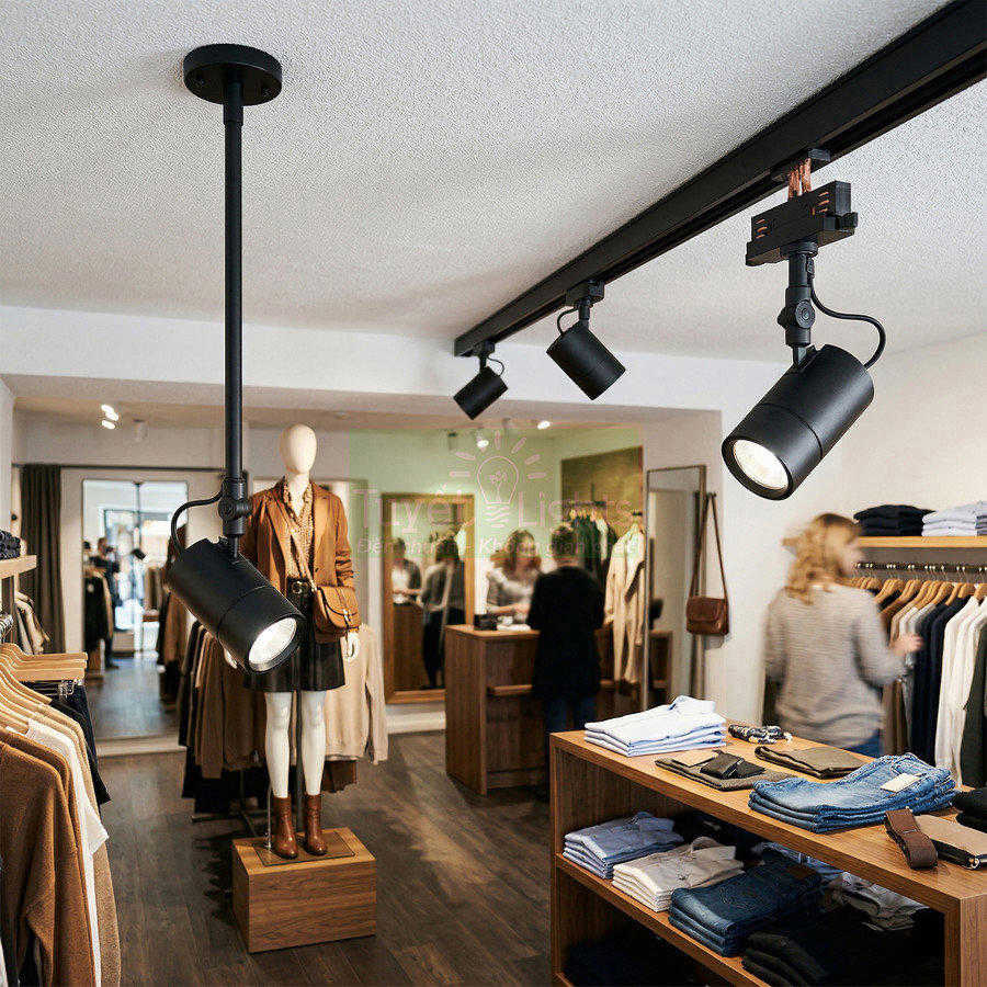 Đèn rọi ray trần màu đen chiếu sáng cửa hàng quần áo thời trang hiện đại