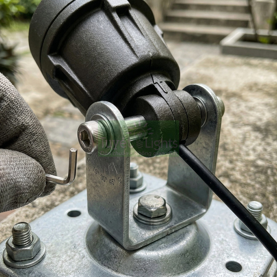 Đèn chiếu sáng ngoài trời gắn chân đế kim loại, đang được chỉnh góc bằng lục giác