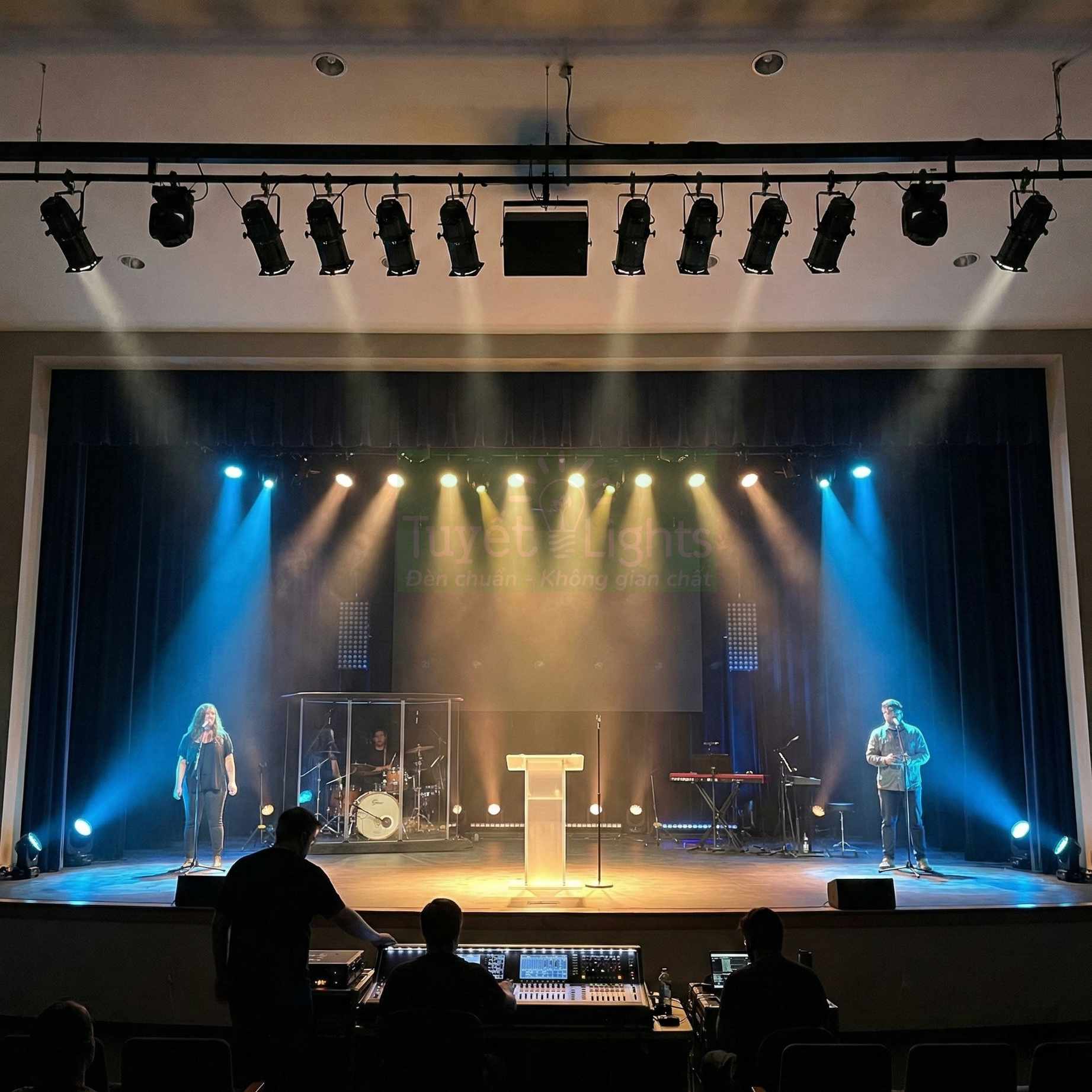 Hệ thống đèn sân khấu chuyên nghiệp chiếu sáng ca sĩ và nhạc cụ trong hội trường biểu diễn